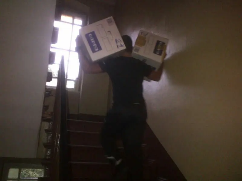 Verhuizer van MBI Verhuisservice draagt dozen de trap op